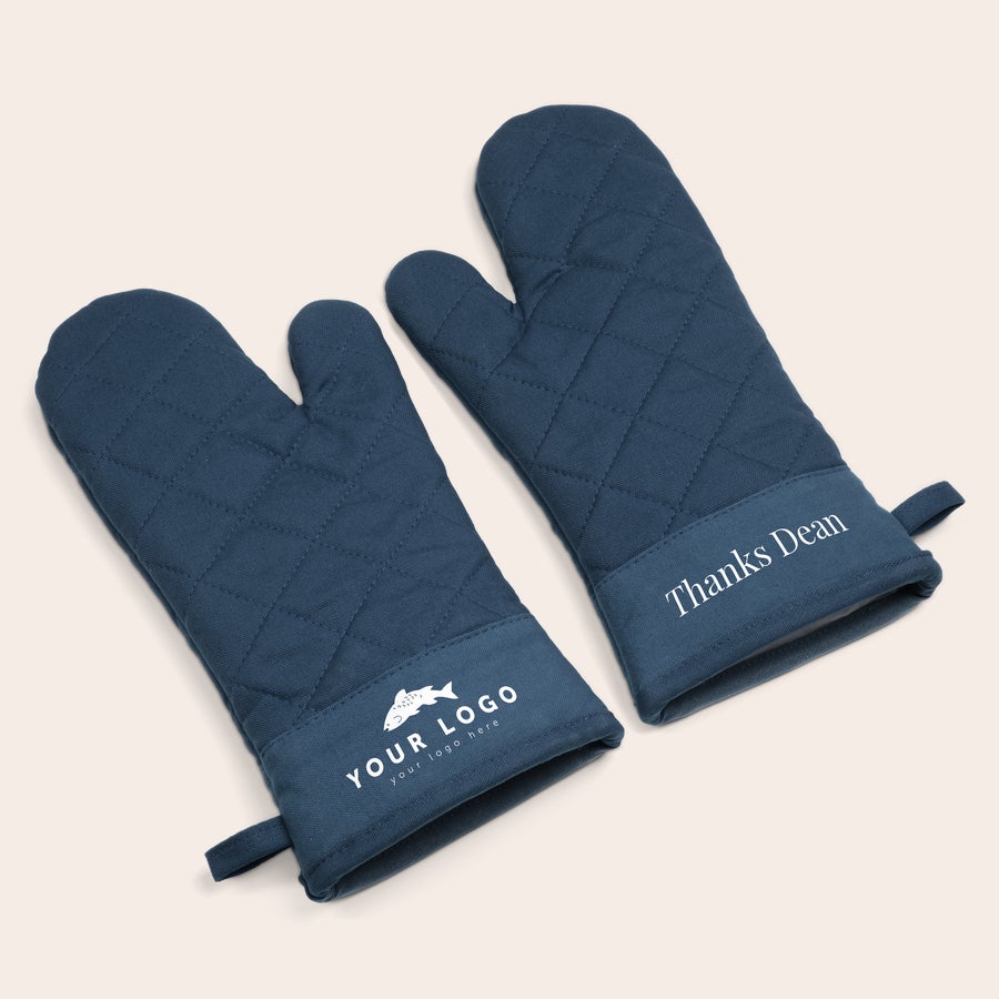 Set de guantes para horno personalizados Guantes de horno azules con patrón acolchado. Un guante dice Thanks Dean y el otro Your Logo here, ambos con impresión blanca. Cocine todo lo que quiera y más con estos guantes de horno personalizados.