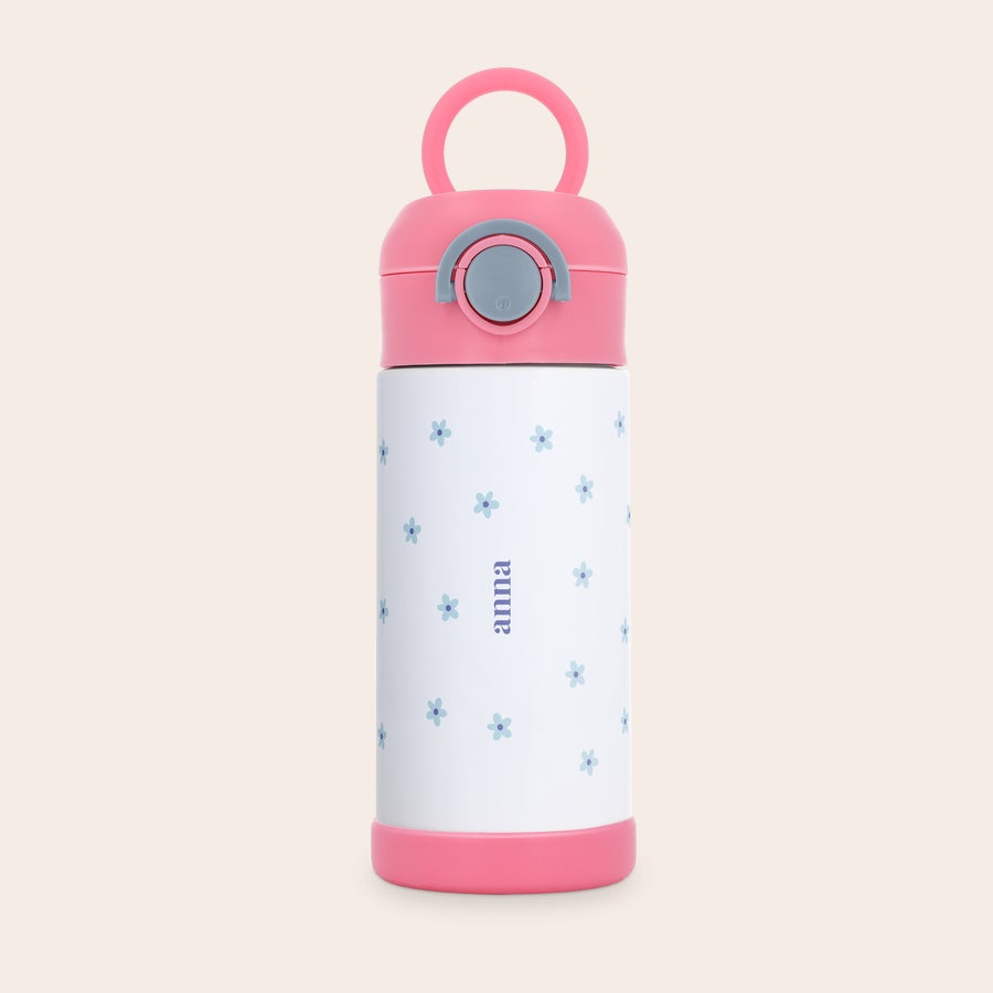 Gobelet bébé personnalisé Gourde enfant en acier inoxydable rose avec nom Anna imprimé et motif de fleurs bleues.