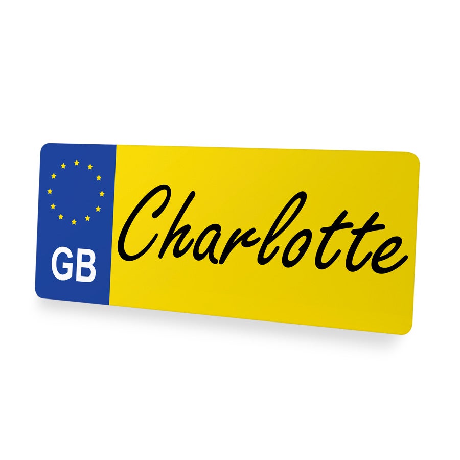 Yksilöllinen brittiläinen numerokilpi Charlotte-nimellä painettuna, keltainen pohja ja sininen GB-merkintä.