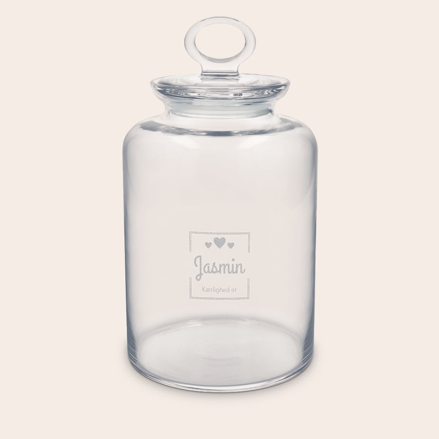 Personligt indgraveret småkagekrukke Personlig småkagekrukke i glas, graveret med navnet "Jasmin" og teksten "Kærlighed er" og hjerter.