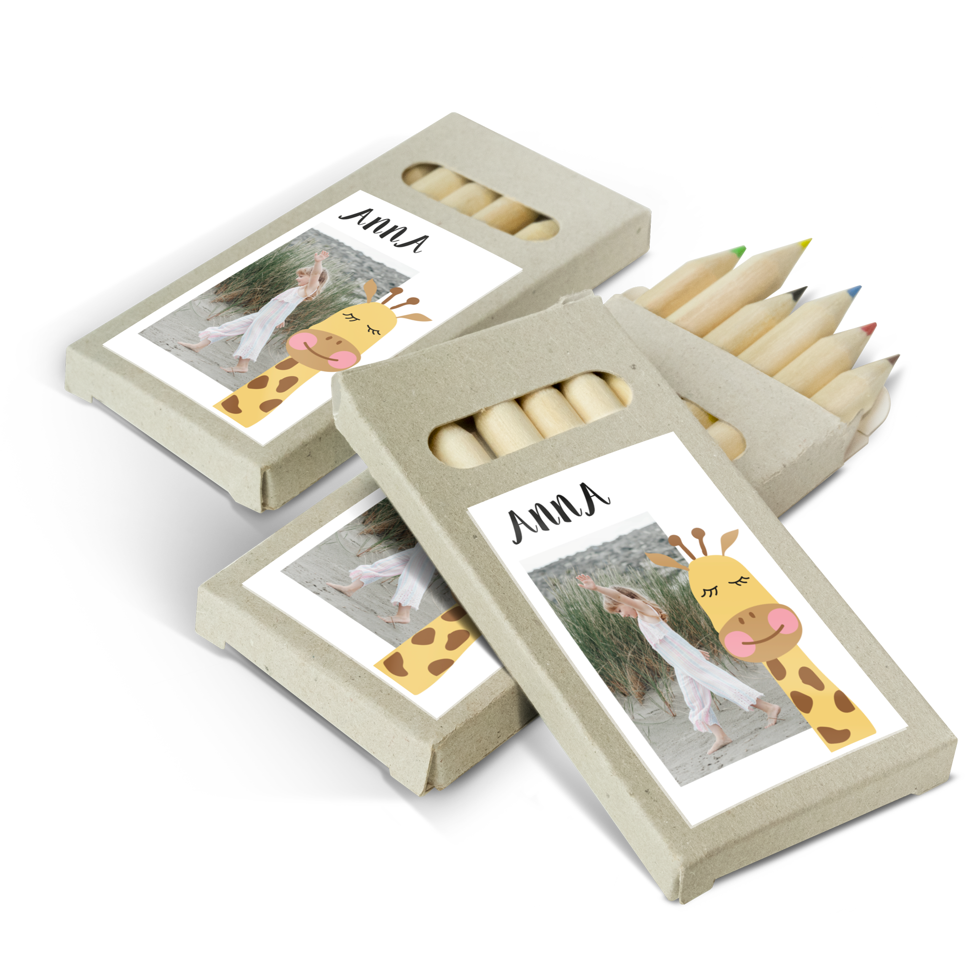 Drei Buntstifte in personalisierter Verpackung mit Foto, Name Anna und Giraffenmotiv als Gastgeschenk.