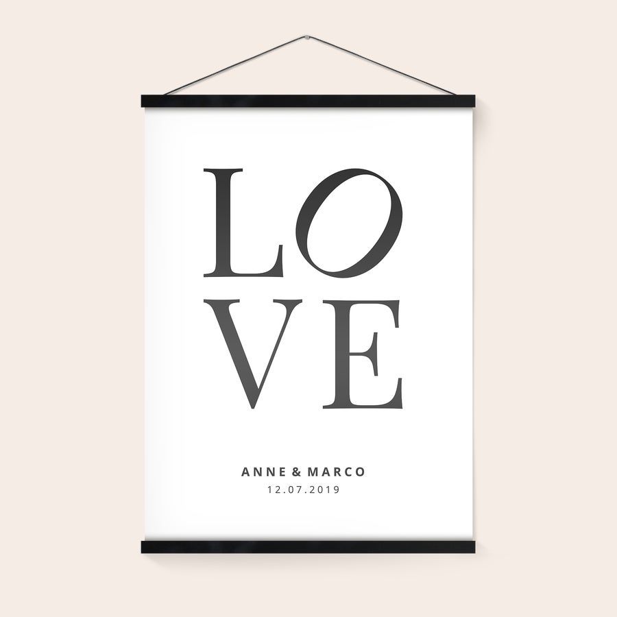 Fotoposter mit magnetischer Posterleiste Fotoposter mit den gedruckten Namen Anne & Marco, dem Datum 12.07.2019 und dem Wort LOVE, gehalten von einer magnetischen Posterleiste