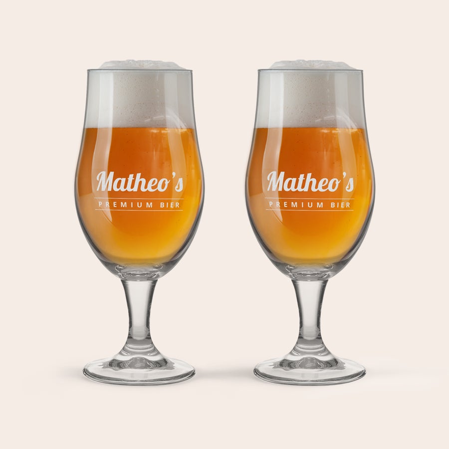Bierglas met naam Twee glazen bier gevuld met pils en schuim, gegraveerd met de naam 'Matheo's Premium Bier'.