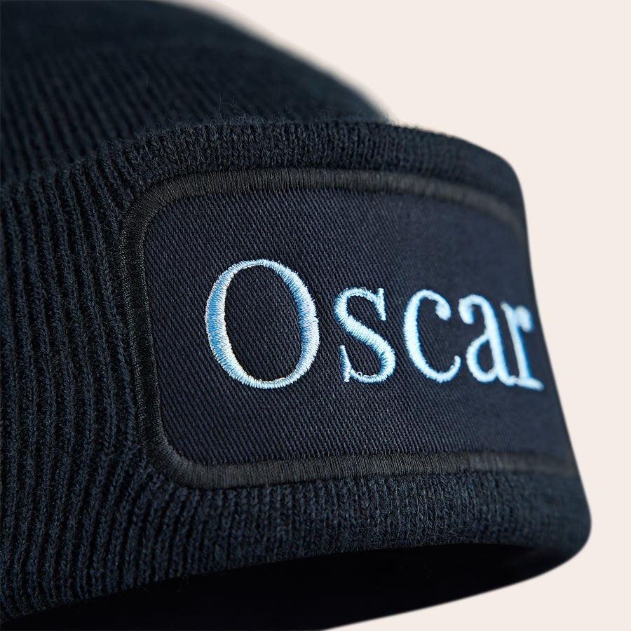 Vyšívaný klobouk Černá čepička s vyšitým jménem Oscar v modré barvě, která udrží ty malé uši pěkné a teplé