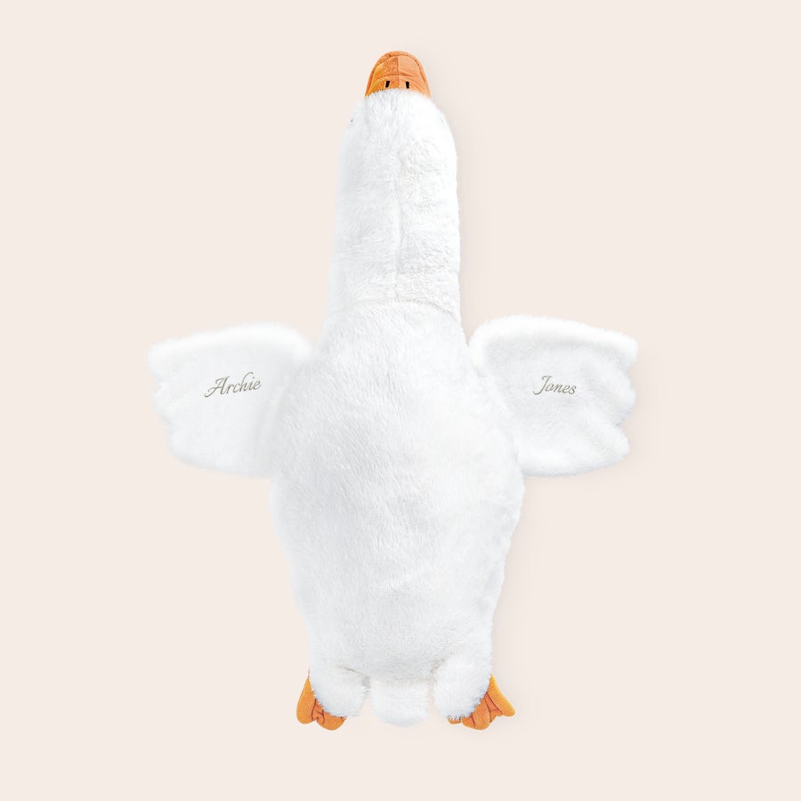 Personligt gosedjur med gås Stort personligt gosedjur i form av en vit gås med broderade namnen Archie och Jones på vingarna