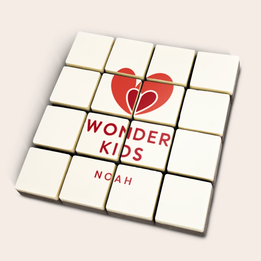 Foto en bloques de chocolate Chocolates personalizados con un corazón rojo, el texto "WONDER KIDS" y el nombre "NOAH" impresos.
