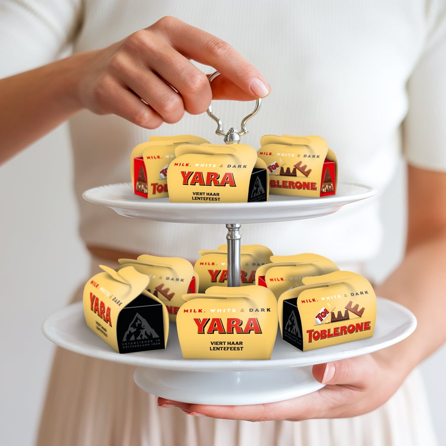 Toblerone mini traktatie personaliseren Gepersonaliseerde Toblerone mini chocolade doosjes met opdruk Yara Viert Haar Lentefeest, gepresenteerd op een etagere voor onvergetelijke momenten.