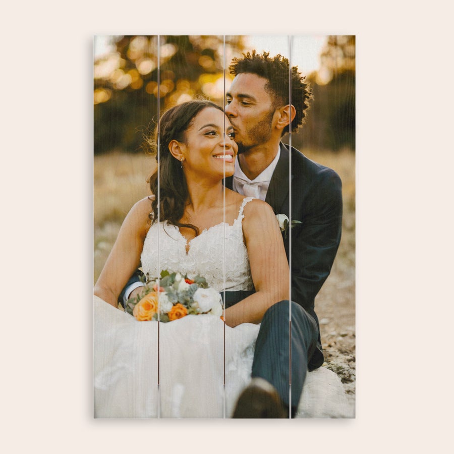 Photo on wood Photo printed onto wooden planks featuring a smiling bride and groom embracing outdoors