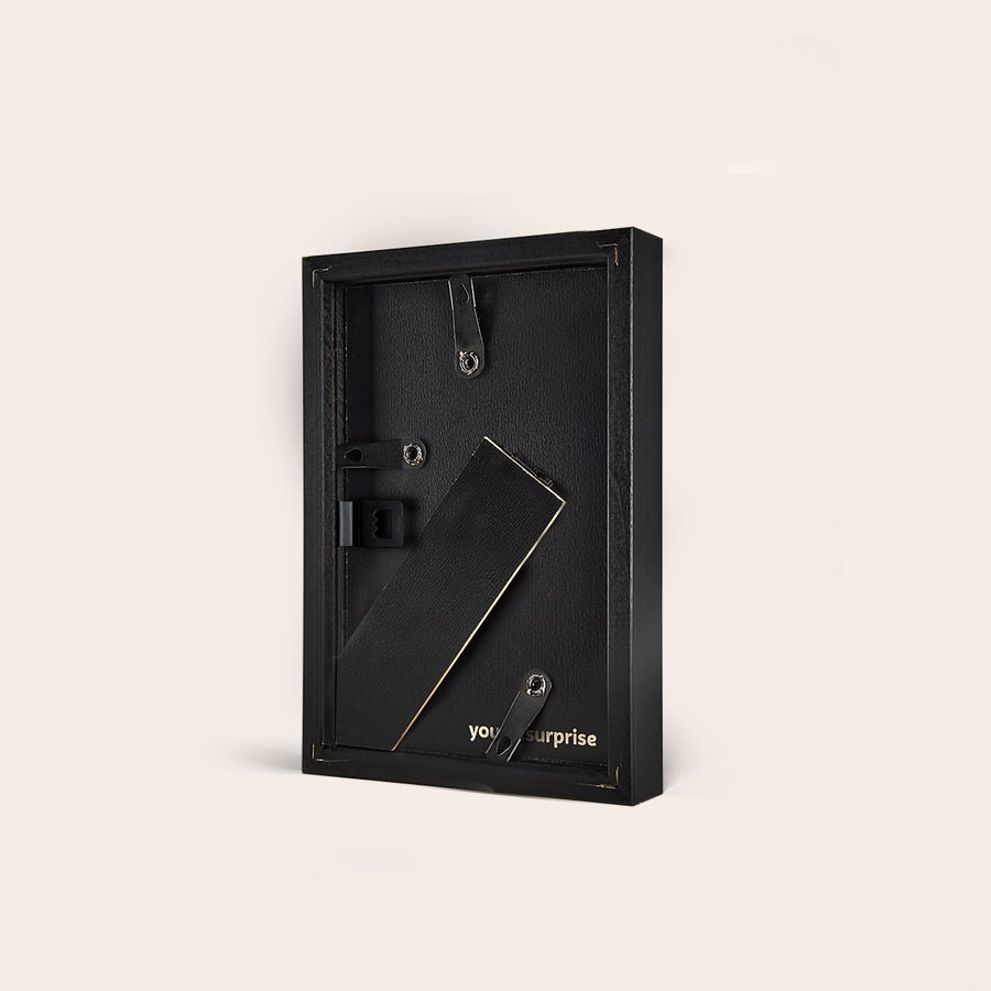 Personalised photo print with frame Back view of two personalized photo prints with black wooden frames, showing the stands and wall hangers