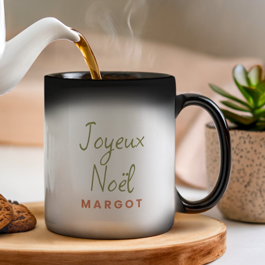 Mug Magique Personnalisé Mug Magique Personnalisé, noir et blanc, avec l'inscription Joyeux Noël Margot. Le texte est imprimé sur le mug qui change de couleur.