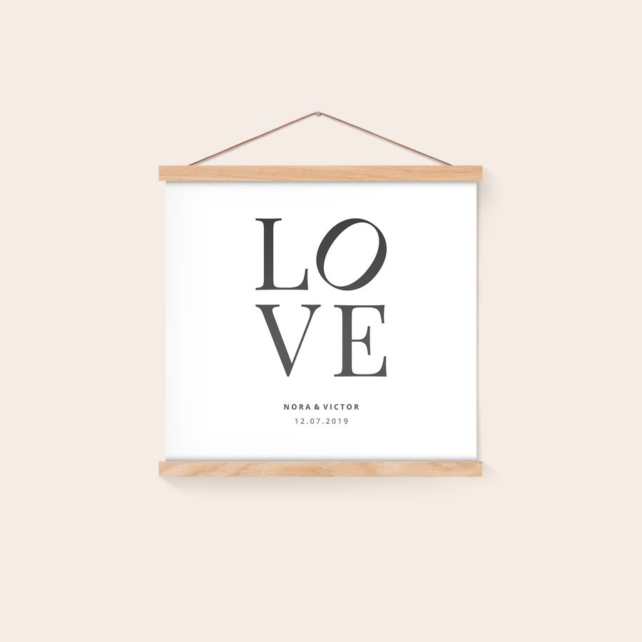 Personlig affisch med trähängare Personlig affisch med texten LOVE och namn Nora & Victor samt datum 12.07.2019, monterad i magnetisk ekram. Häng upp ditt vackraste fotoögonblick på väggen med denna praktiska magnetiska affischhängare