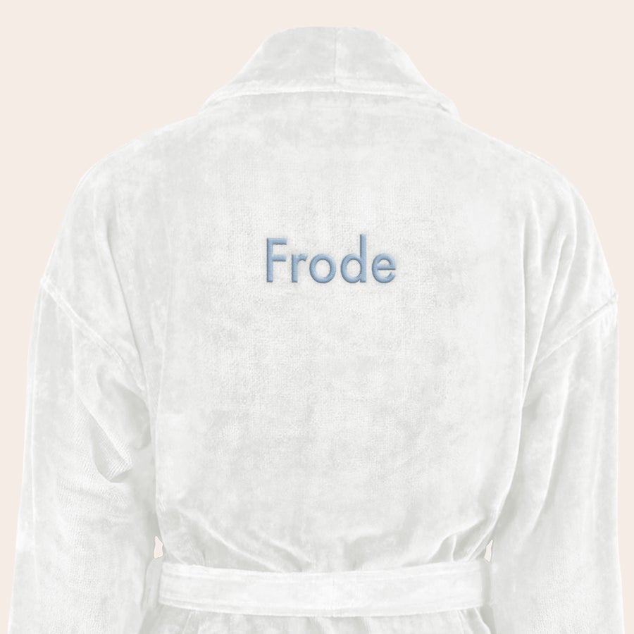Badekåpe for menn med navn Myk hvit badekåpe brodert med navnet "Frode" i lyseblått.