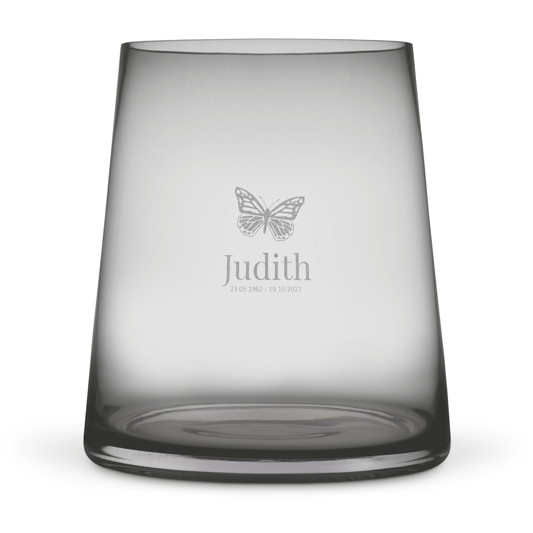 Gegraveerde vaas van getint glas met een vlinderdesign, de naam Judith en datums 23-05-1962 - 19-10-2022. Fleur het huis op met een gegraveerde vaas.