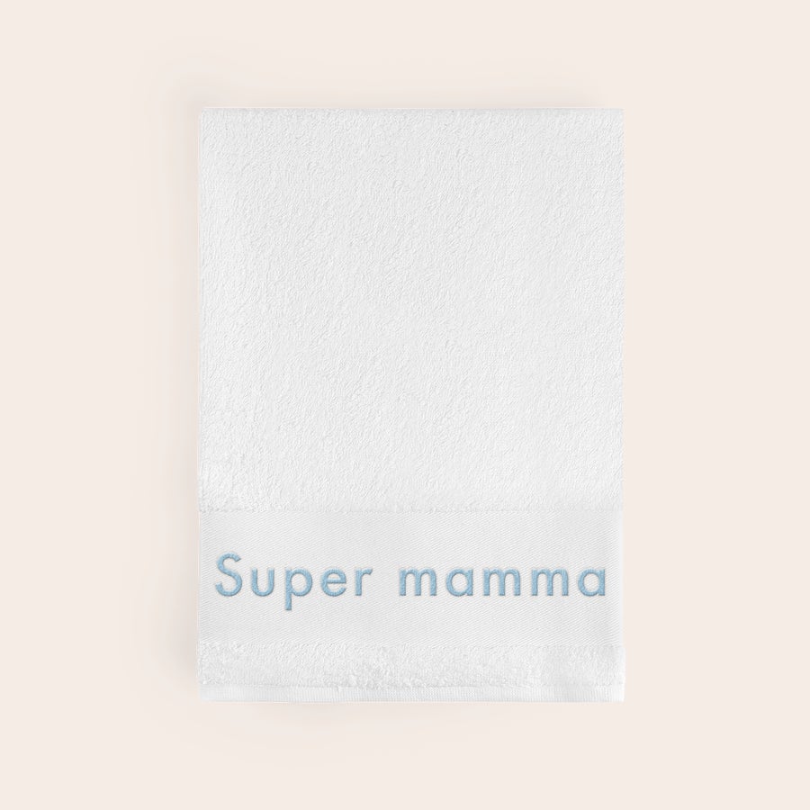 Handduk med Text Vit supermjuk handduk broderad med namnet Super mamma i ljusblå tråd