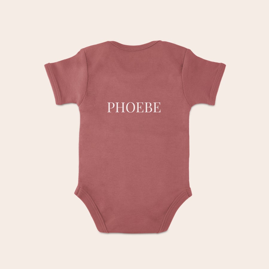 Baby bodysuit Rosafarget personlig tilpasset babydress med trykket navnet PHOEBE i hvite bokstaver.