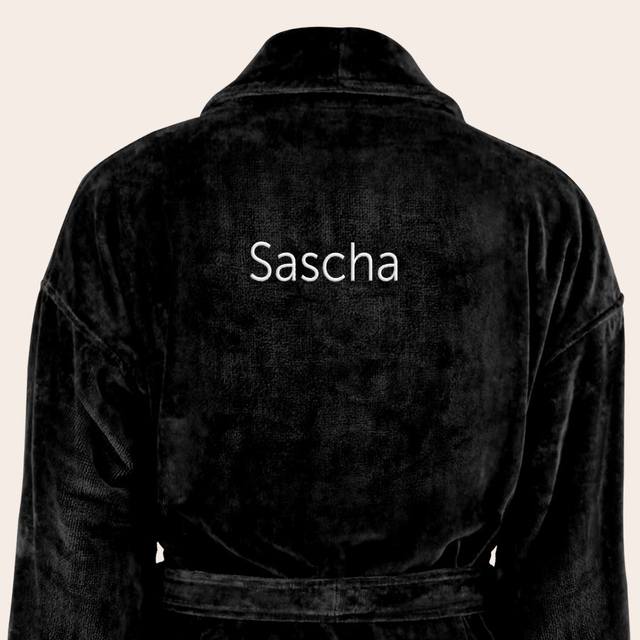 Bademantel Männer personalisiert Schwarzer Bademantel mit Namen Sascha, auf dem Rücken mit hellem Garn bestickt.