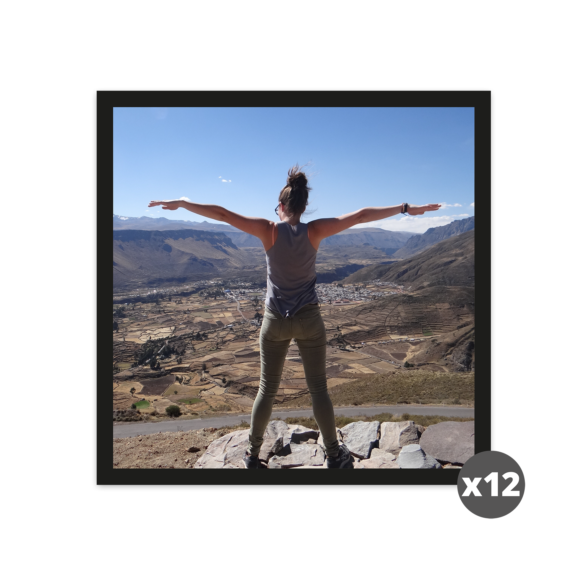 A printed square photo showing a person standing with outstretched arms overlooking a valley, emphasizing custom memories. The photo is one of a pack of 12.