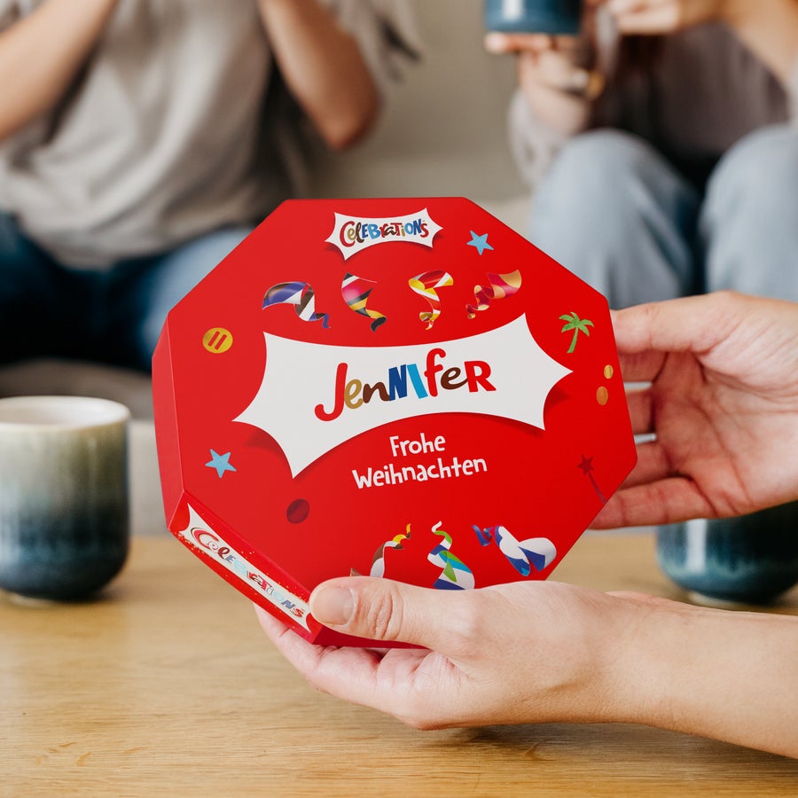 Celebrations Chocolate Box mit Namen Rote Celebrations Chocolate Box mit dem Namen Jennifer und Frohe Weihnachten personalisiert, gehalten in Händen.