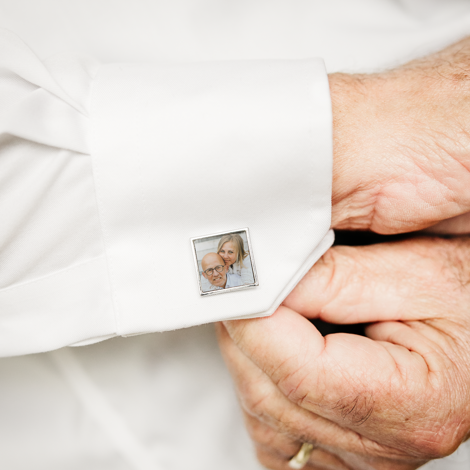 Boutons de manchette carrés personnalisés avec une photo imprimée d&#x27;un couple souriant, portés sur une chemise blanche.