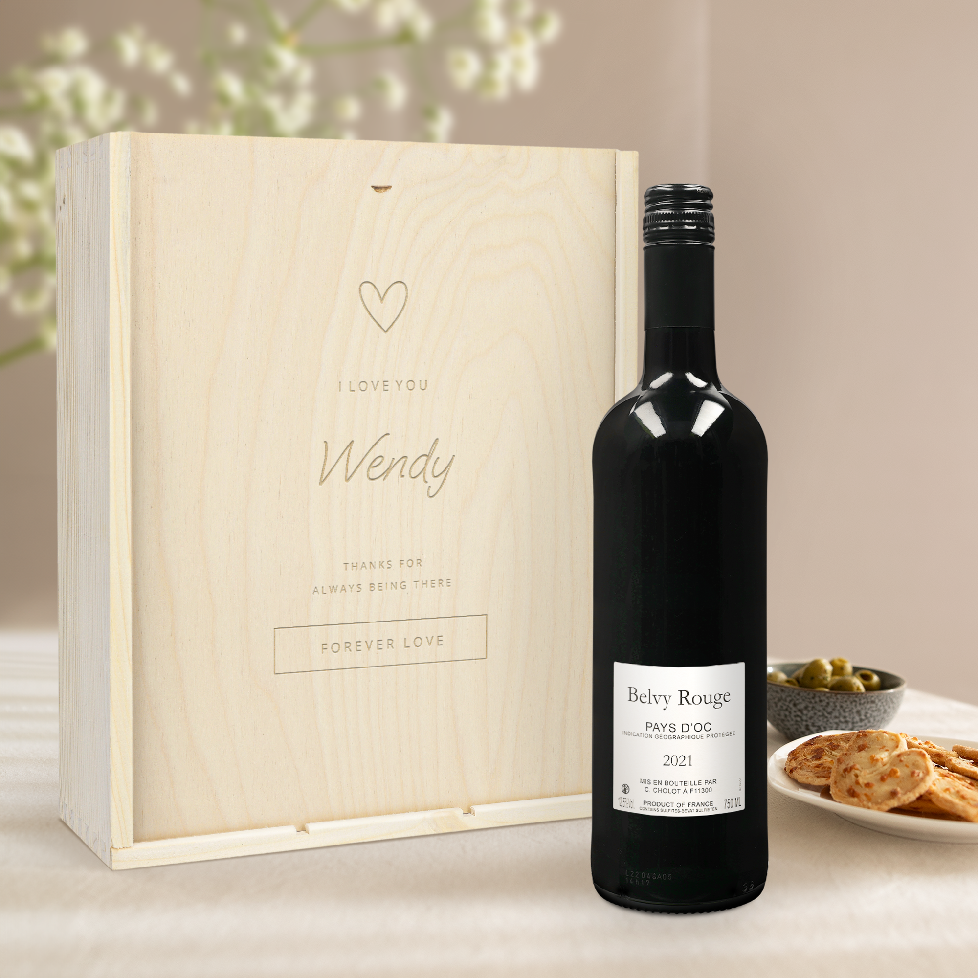 Caja de vino Belvy de madera grabada con el nombre Wendy y un diseño de corazón, junto a una botella de vino tinto Belvy.