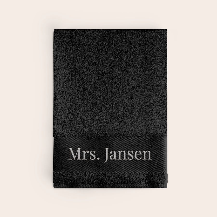 Handdoek met naam Zwarte handdoek met geborduurde naam "Mrs. Jansen", een gepersonaliseerde handdoek met naam