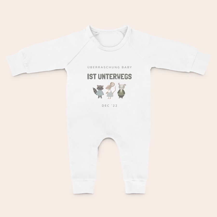 Babystrampler bedrucken Weißer Babystrampler bedruckt mit dem Text "ÜBERRASCHUNG BABY IST UNTERWEGS", Tiermotiven und "DEC '22". Dieser Babystrampler ist eine tolle Überraschung für die frischgebackenen Eltern.