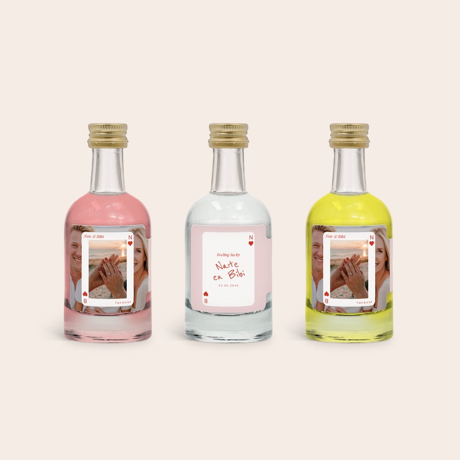 Degustare de alcool în miniatură - Gin roz - Limoncello - Gin Trei mini sticle personalizate de alcool roz, transparent și galben, cu etichete tipărite cu fotografii și text "Nate & Bibi" și "02.05.2025" pentru un set personalizat de degustare de alcool în miniatură.