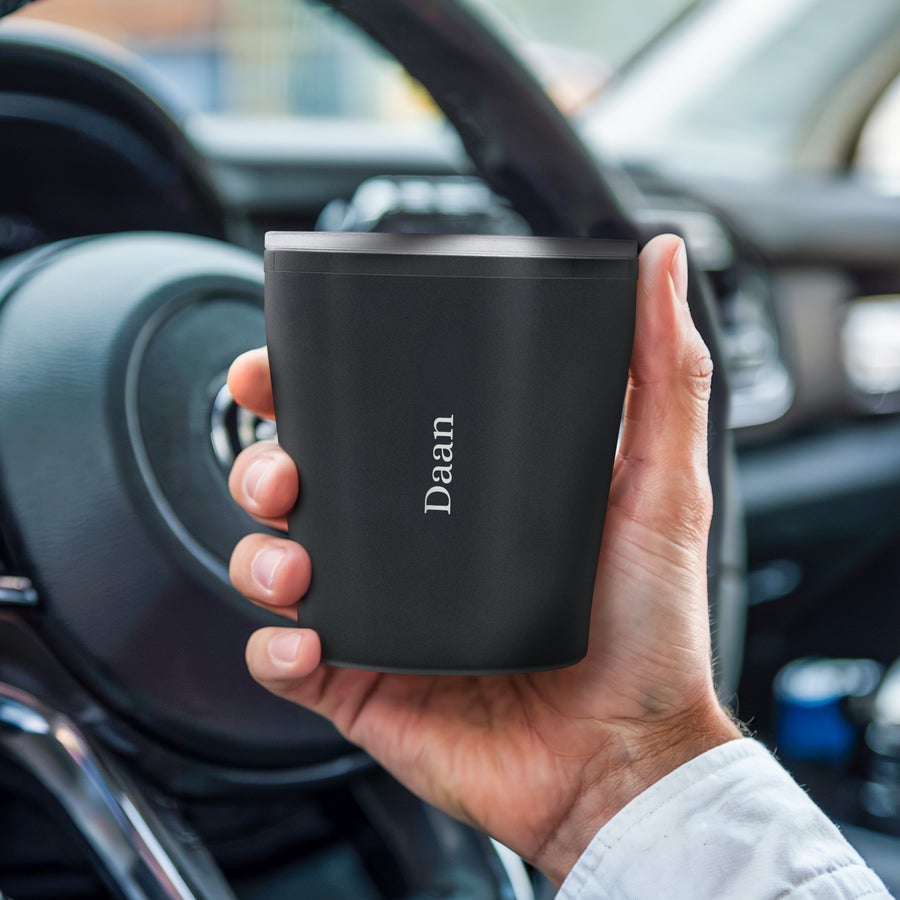 Koffiebeker to go met naam en/of tekst Gepersonaliseerde koffiebeker to go met de naam Daan bedrukt, vastgehouden in een auto