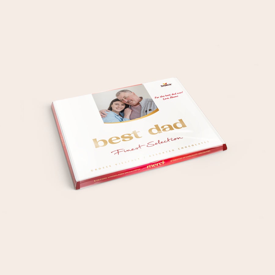 Personlig Merci-sjokolade i gaveeske med gratulasjonskort Hvit Merci sjokoladeeske med et personlig kort trykt med bilde, tekst For the best dad ever! Love, Naomi og overraske.