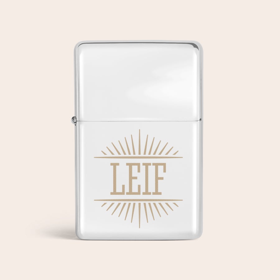 Graverade tändare Silverfärgad metalltändare med en graverad namntändare av namnet LEIF, omgivet av solstrålar.