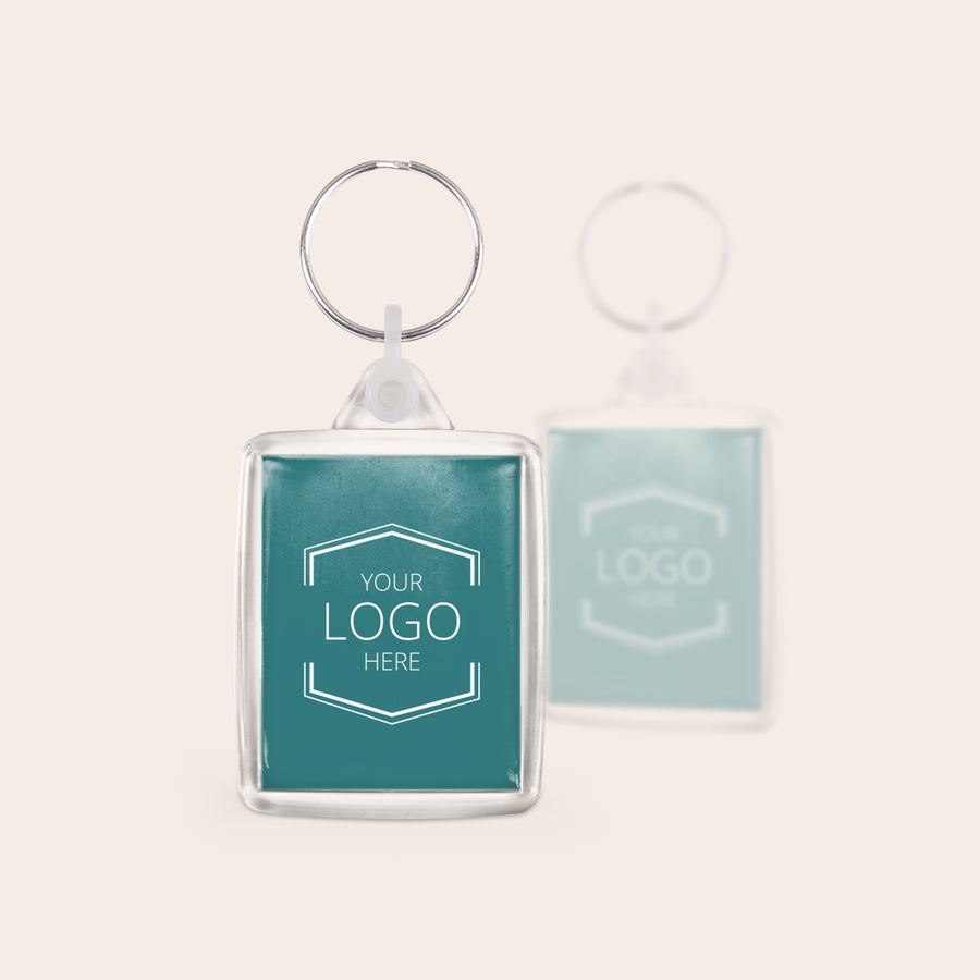 Sleutelhanger met logo Unieke set sleutelhangers met bedrukking van een eigen logo in blauw, met een vage variant op de achtergrond.