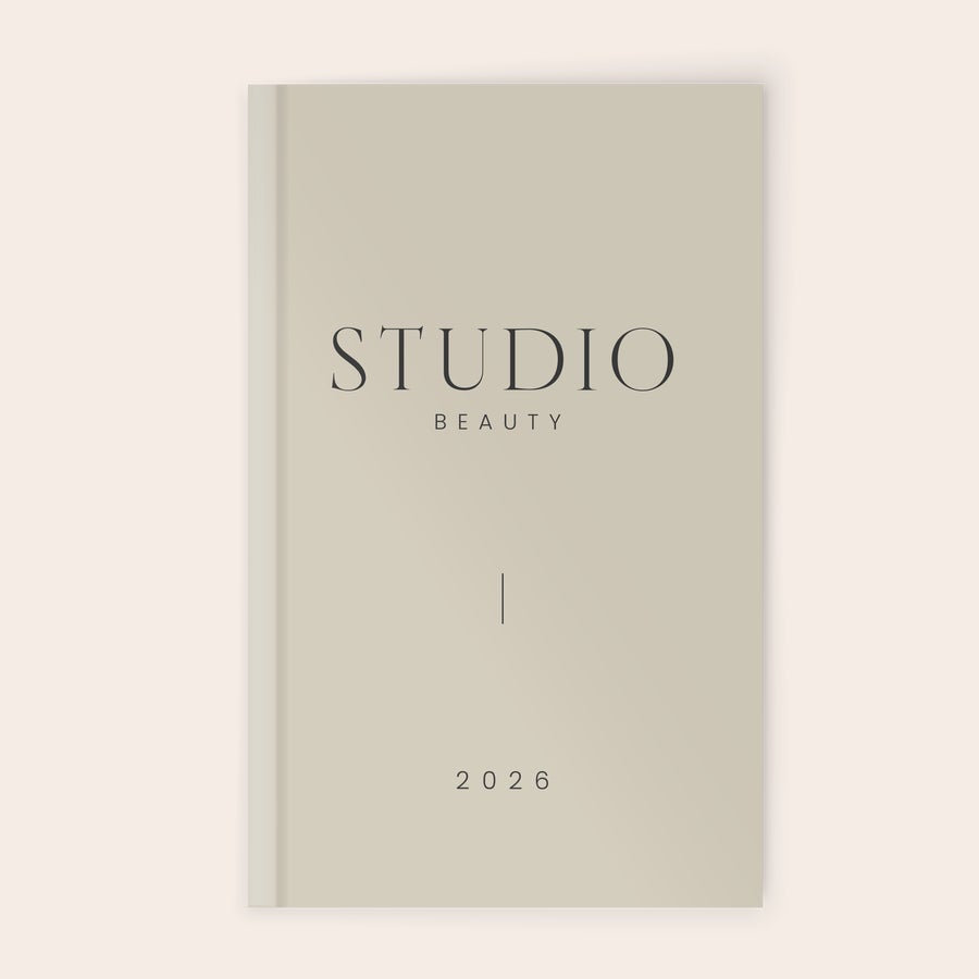 Agenda personalizada Agenda personalizada 2026 con tapa gris claro, con texto STUDIO BEAUTY y año 2026 impreso en la portada.