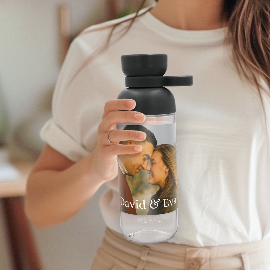 Botellas Mepal Vita Botella Mepal personalizada con foto impresa de pareja y los nombres David & Eva, agarrada por una persona.