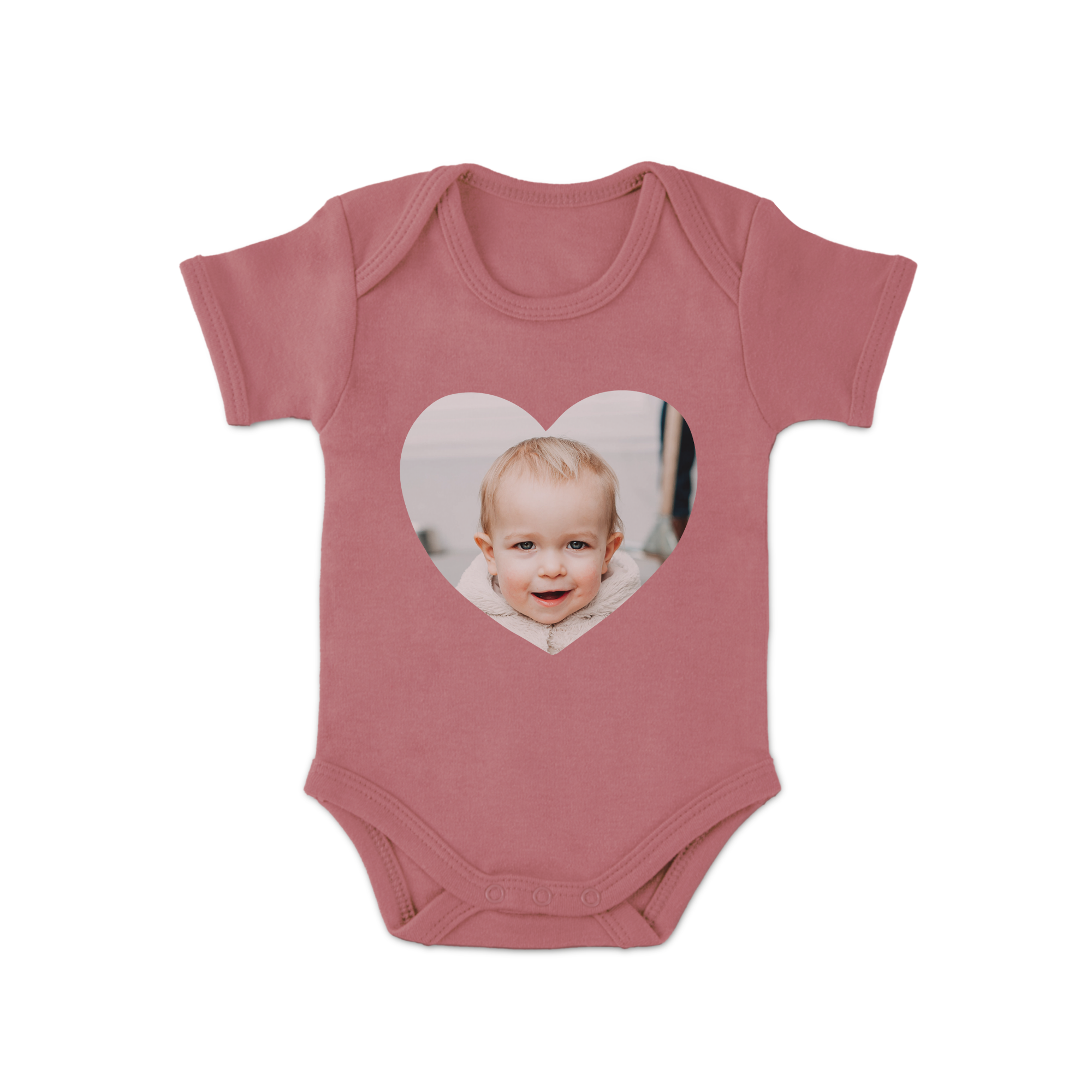 Roze rompertje bedrukt met een hartvormige foto van een lachende baby voor kersverse ouders.
