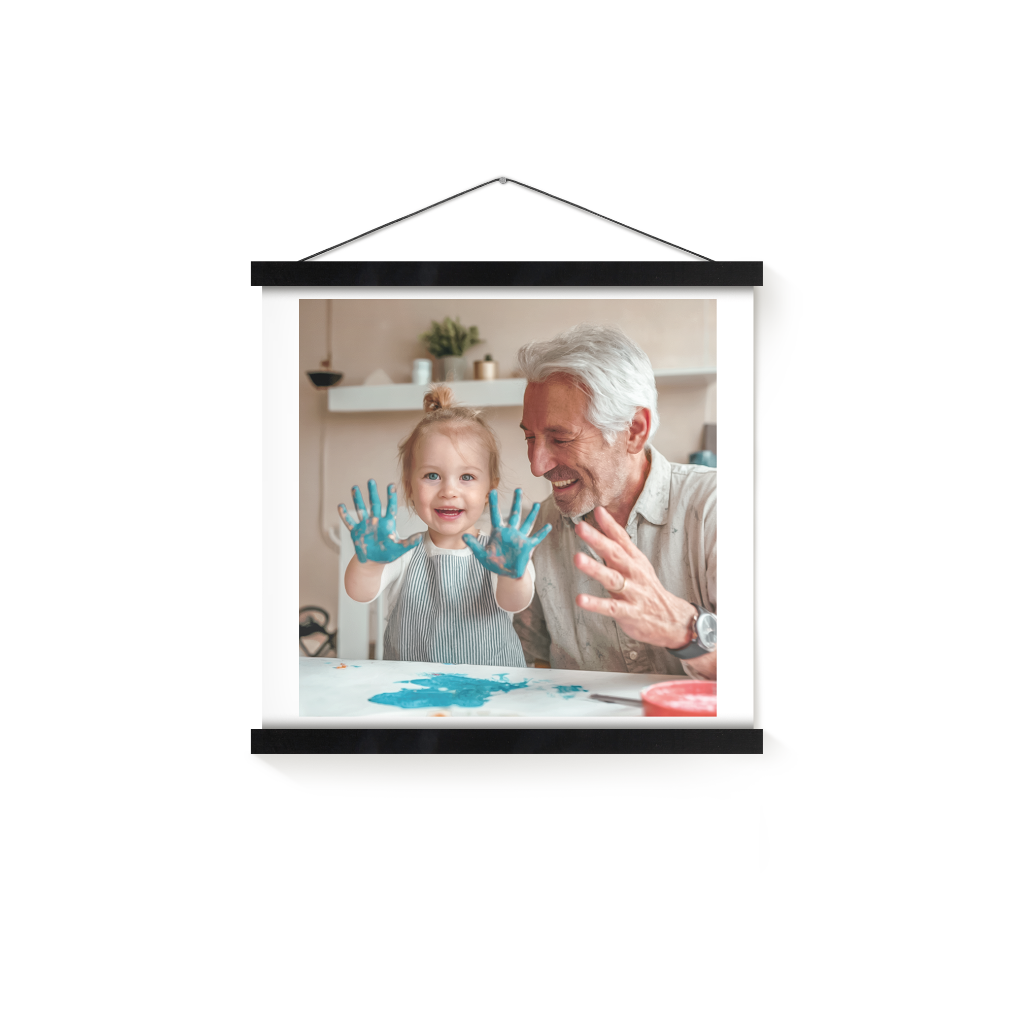 A personalized photo poster with a magnetic poster hanger displays a photo of a toddler and an older man with blue paint on their hands.