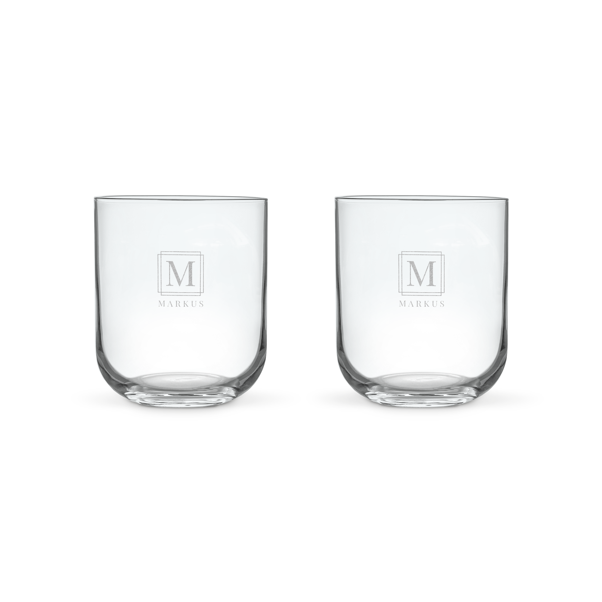 Två lyxiga personliga vattenglas lasergraverade med bokstaven M och namnet Markus. Ett glas vatten smakar mycket bättre i ett lyxigt personligt vattenglas.