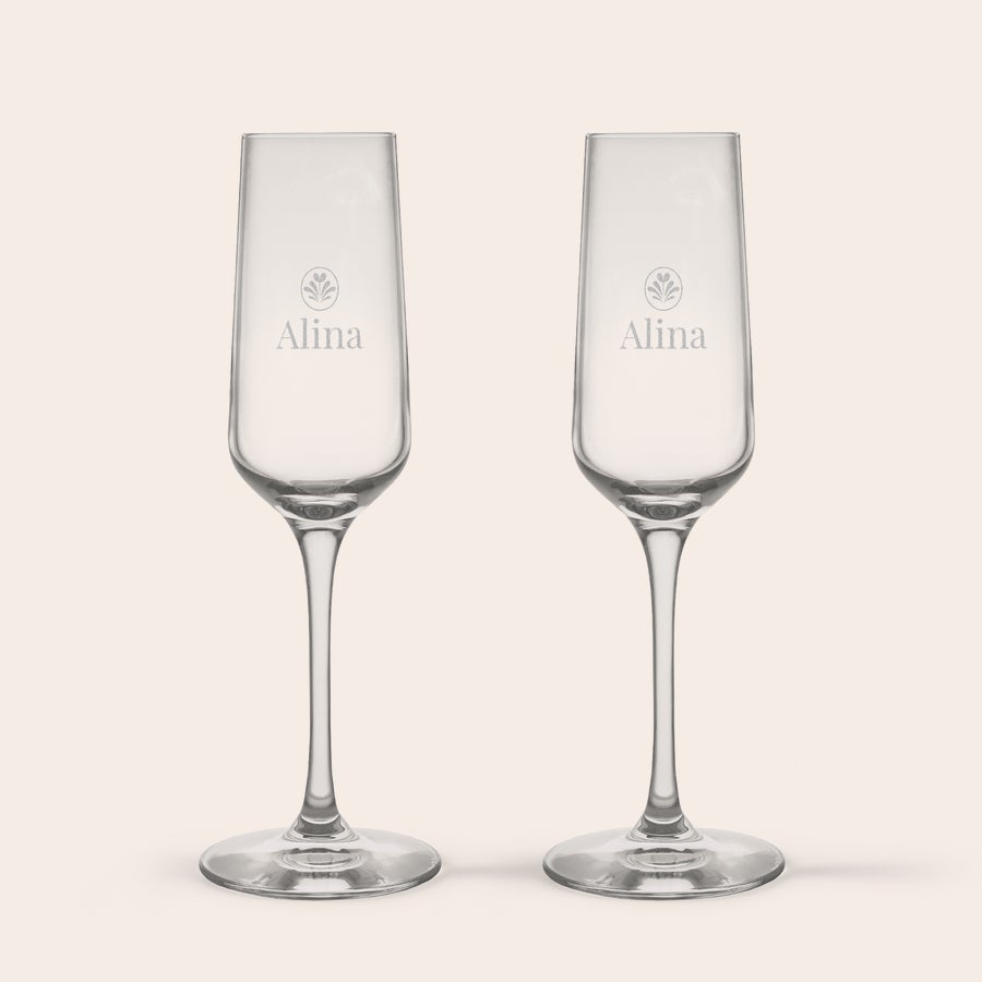 Champagneglas Två personliga kristallglas med champagne gravyr texten "Alina" och ett dekorativt lövmotiv ovanför