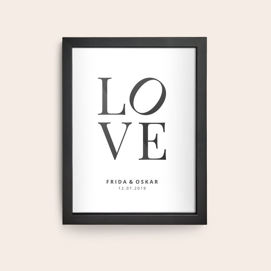 Innrammet bilde Plakat i svart treramme med trykt bilde og navnene Frida og Oskar, samt datoen 12.07.2019.