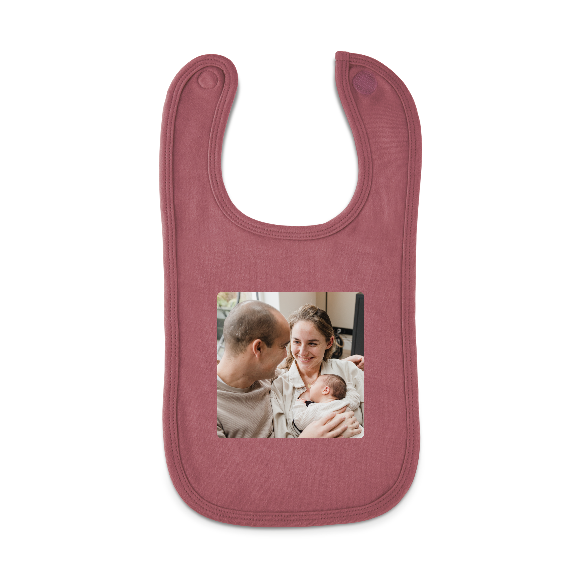 Babero personalizado de color rosa salmón con foto impresa de padres y su bebé.