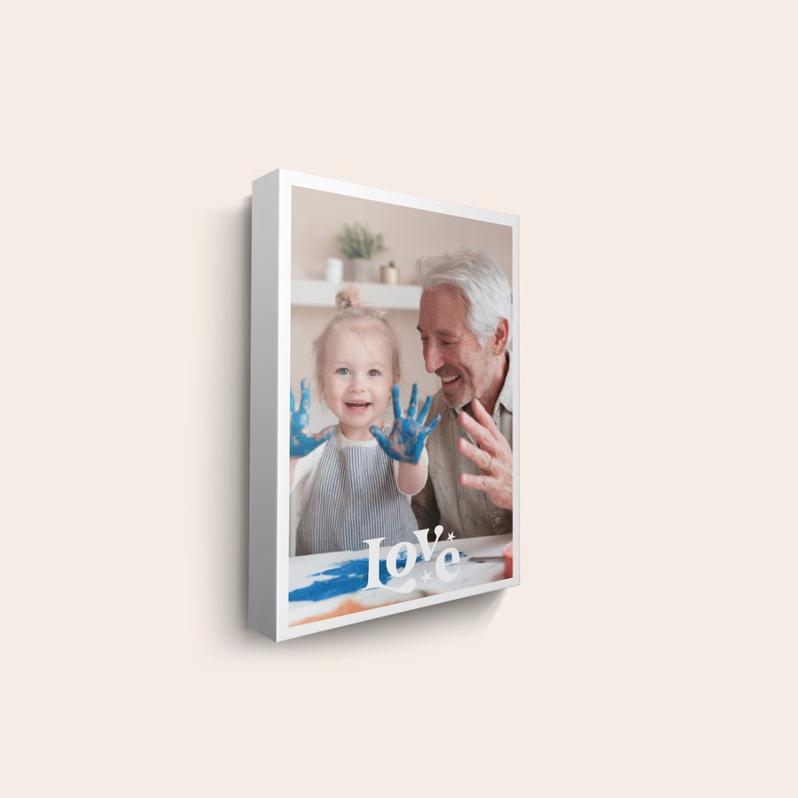 Canvas-taulu Canvas-taulu omalla kuvalla, jossa isoisä ja lapsi maalaavat. Love-teksti painettuna kuvaan.