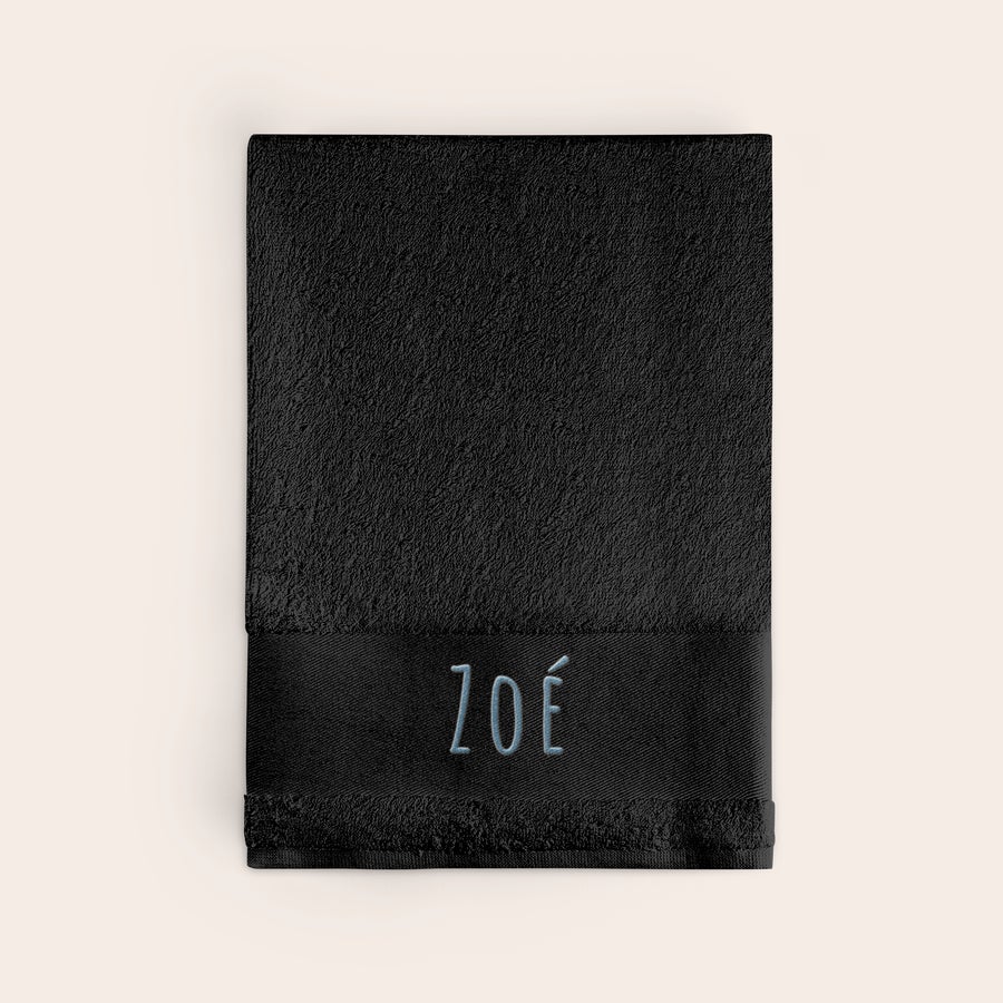 Serviette de bain personnalisée Serviette noire brodée avec le prénom Zoé en fil bleu clair. Rendez chaque moment du bain unique.