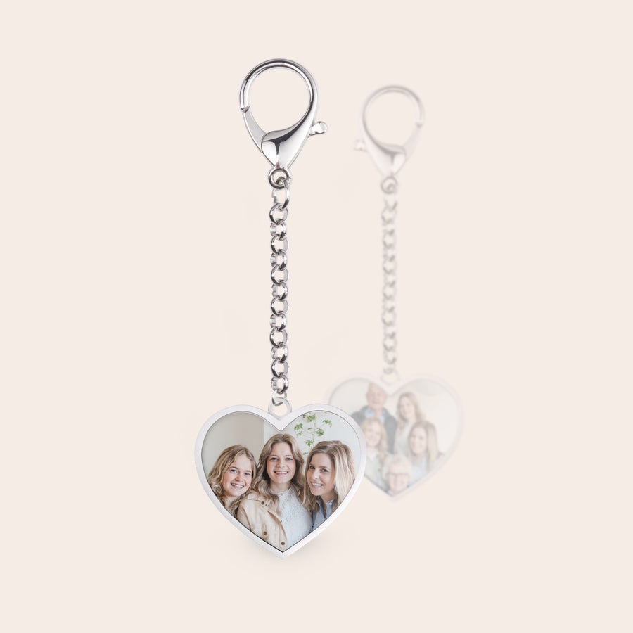 Personalised key ring - Stainless steel Two silver heart-shaped photo keyrings with custom printed photos on both sides, one showing three young women and the other showing a family.