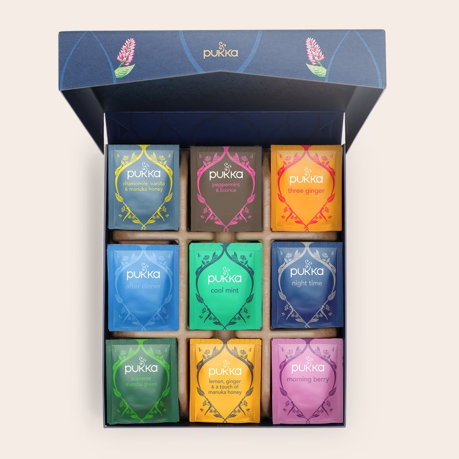 Chá Pukka personalizado Caixa azul escura com 9 tipos de chá Pukka visíveis, incluindo camomila e menta. O Teu Refúgio Personalizado para Chá Aguarda.
