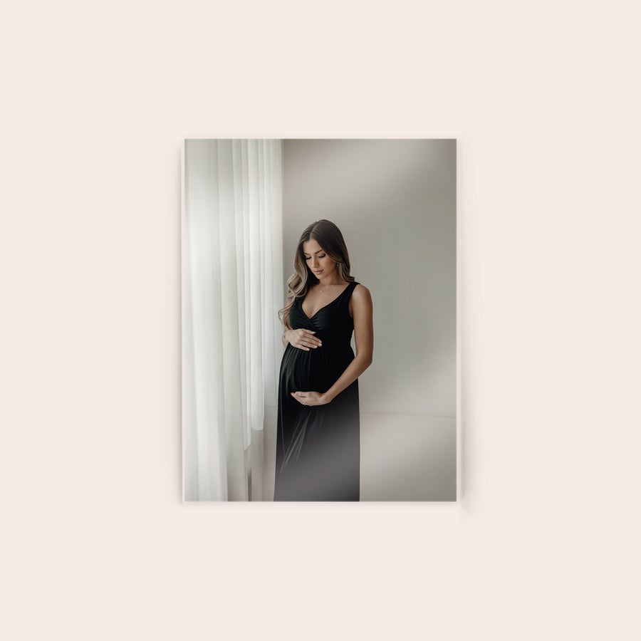 Fotografie pe acrilic Fotografie acrilică personalizată cu o femeie însărcinată într-o rochie neagră lângă o fereastră, pentru a imortaliza cel mai memorabil moment.