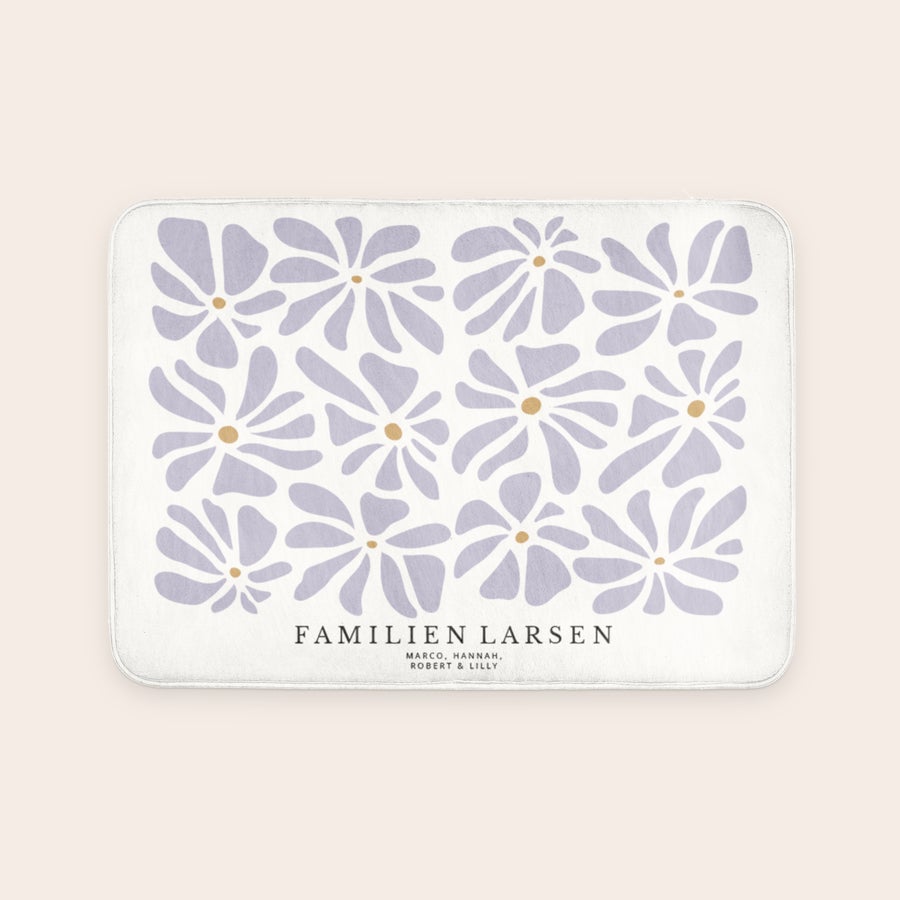 Personlig bademåtte - 70 x 50 cm Personlig bademåtte med lilla blomsterprint og teksten "FAMILIEN LARSEN" for at forvandle ethvert badeværelse til et personligt fristed.