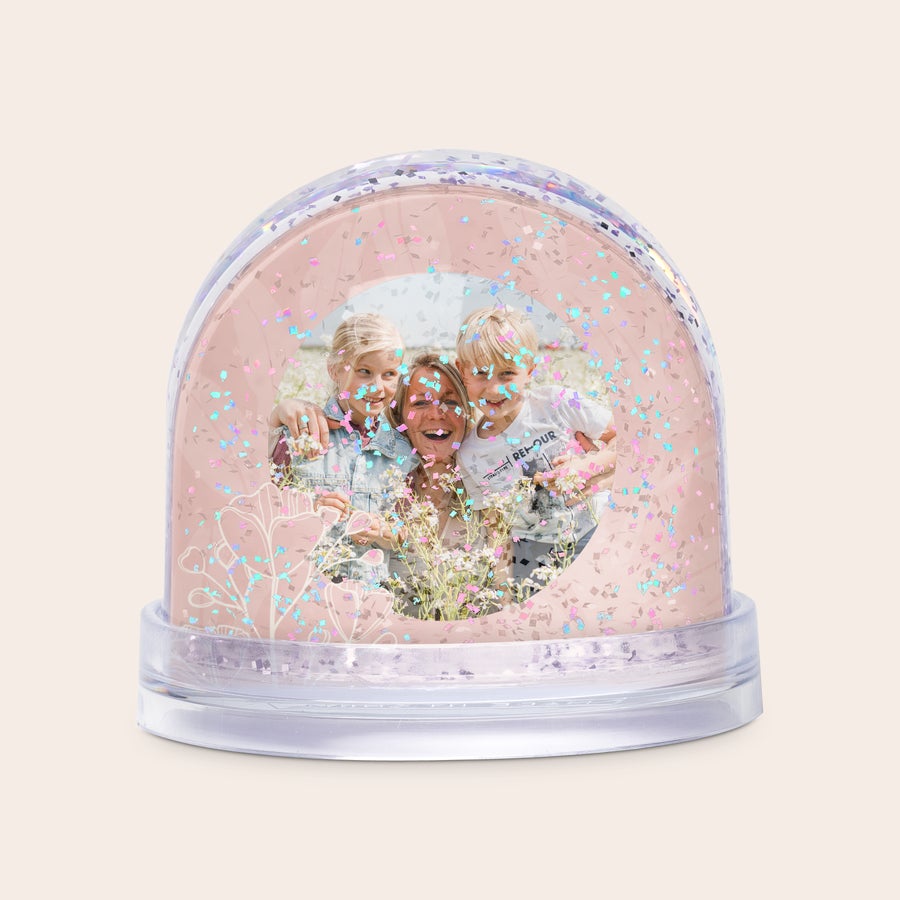 Snöglob Personifierad snöglob med glitter och ett tryckt foto på en glad mamma med två barn som en överraskande present