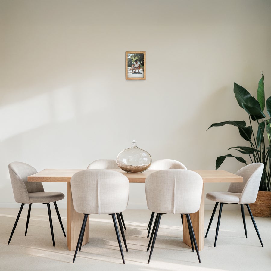 Personalised photo print with frame A personalized photo print in a light brown wooden frame hanging on a wall in a dining room