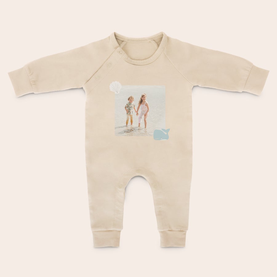 Babystrampler bedrucken Dieser Babystrampler ist eine tolle Überraschung: beiger Baumwoll-Babystrampler mit langen Ärmeln, bedruckt mit einem individuellen Foto von zwei Kindern im Wasser und zwei kleinen Motiven Muschel und Wal.