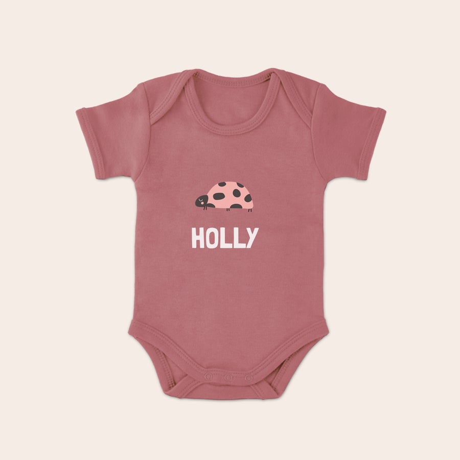 Vauvan bodysuit Vaaleanpunainen potkupuku painatuksella, jossa leppäkerttu ja nimi Holly