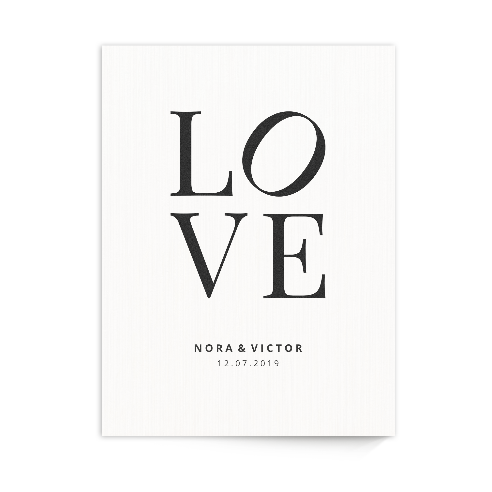 Fotopåminnelse tryckt på trä med texten LOVE, och namnen Nora & Victor med datumet 12.07.2019 under